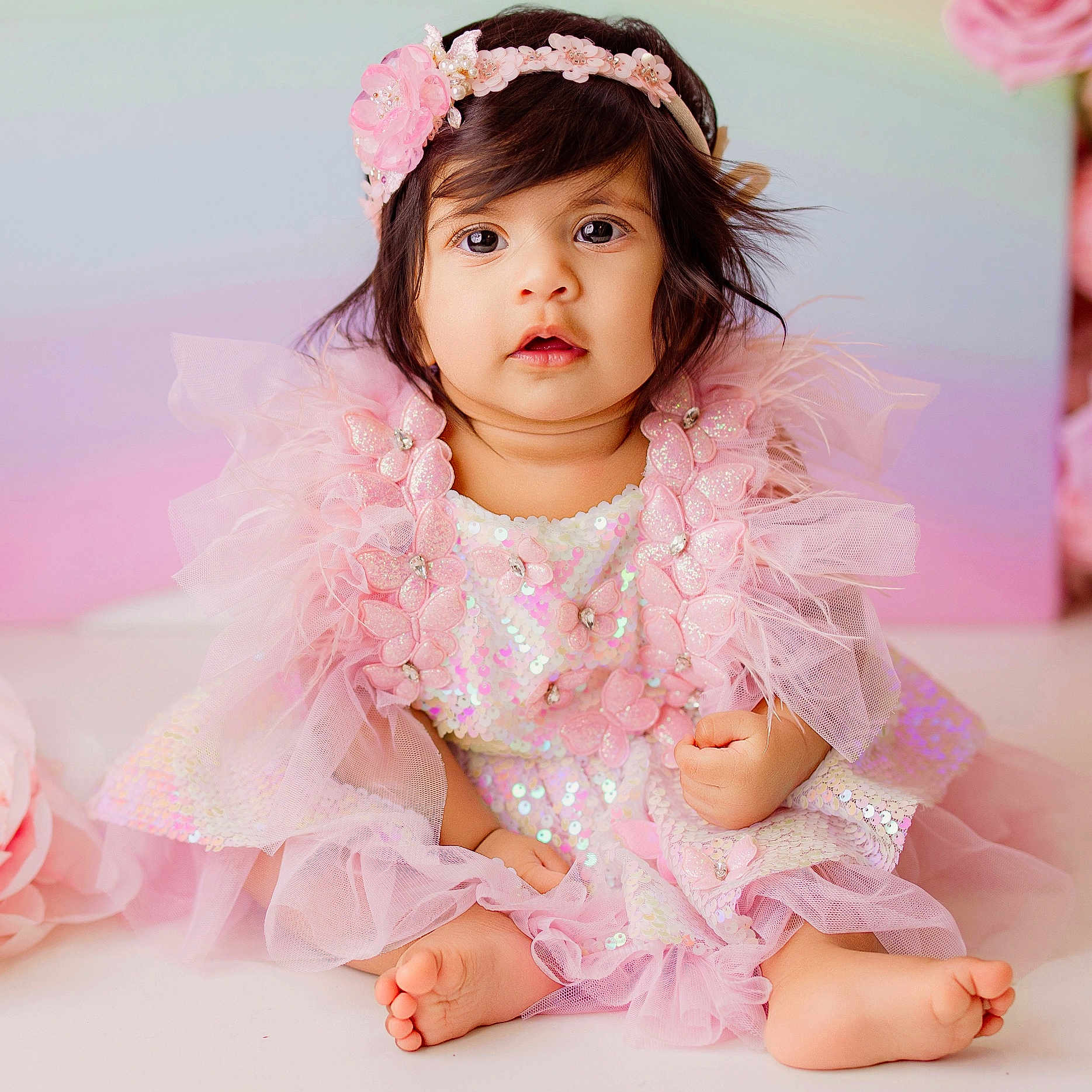 Vamika Reddy is registered to the contest to win money with this photo: adorable, baby, barefoot, child, closeup, cute, decor, flower, girl, happy, headband, indoors, infant, pastel_background, pink_dress, portrait, sequins, sitting, soft_lighting, tulle