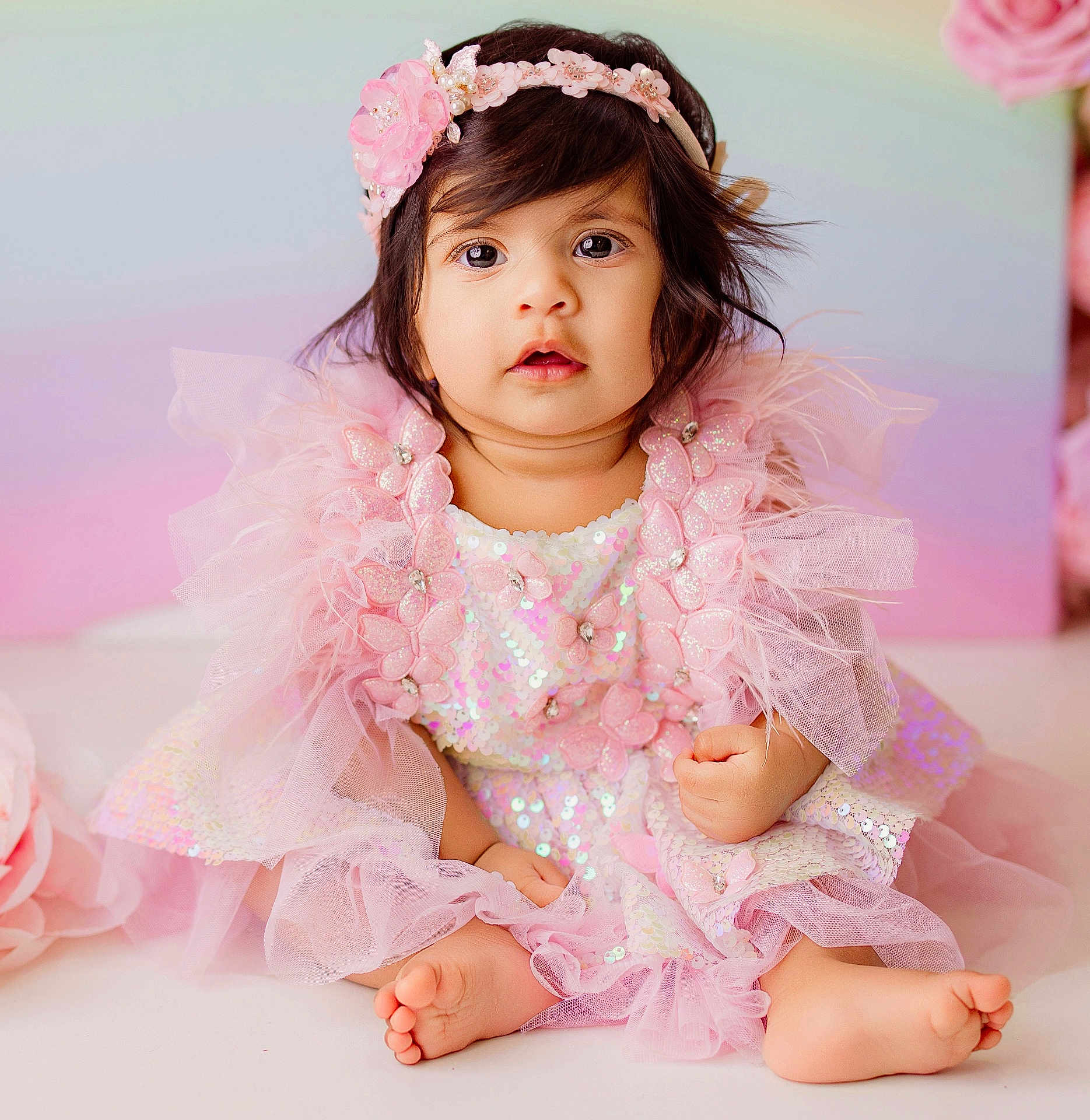 Vamika Reddy is registered to the contest to win money with this photo: baby, child, girl, pink_dress, headband, flower, sitting, cute, portrait, indoors, soft_lighting, tulle, sequins, happy, barefoot, infant, adorable, closeup, decor, pastel_background