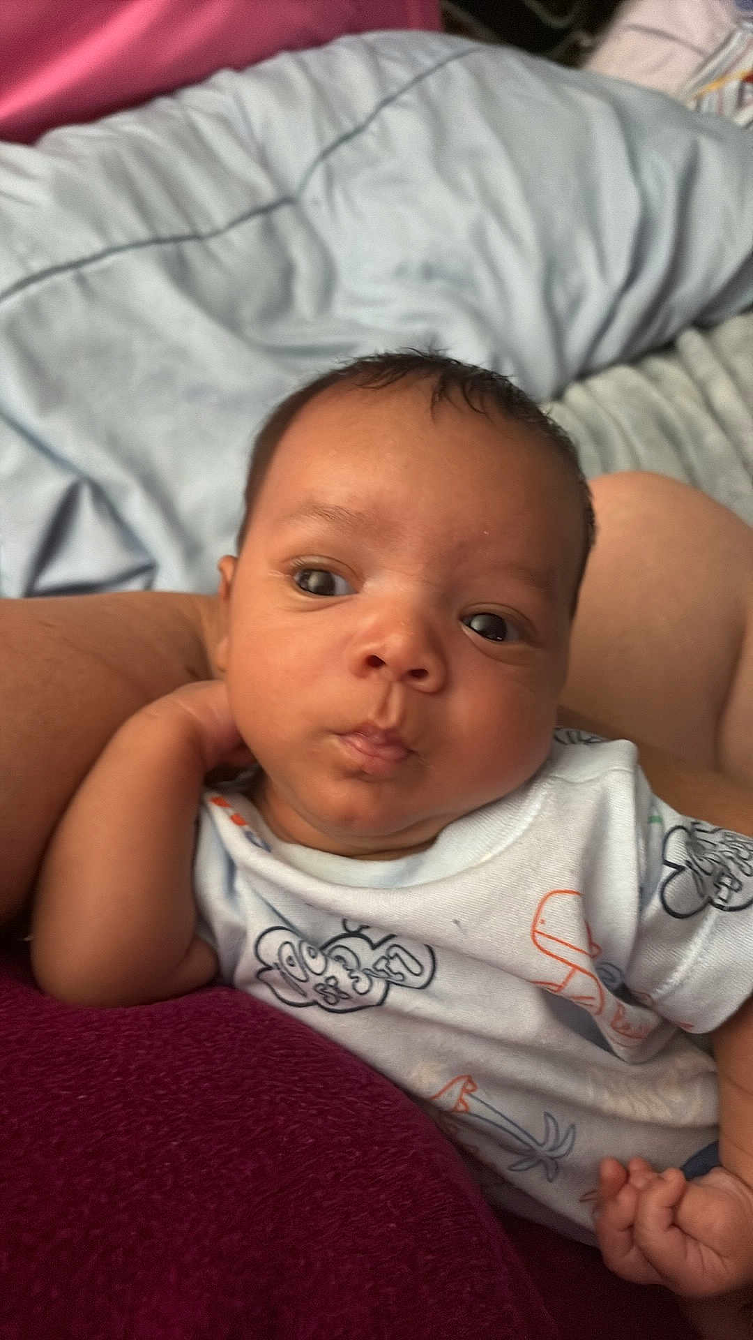 Tyler is registered to the contest to win money with this photo: baby, infant, child, person, face, clothing, onesie, hand, arm, blanket, bed, soft, cute, expression, indoor, skin, young, resting, comfort, portrait