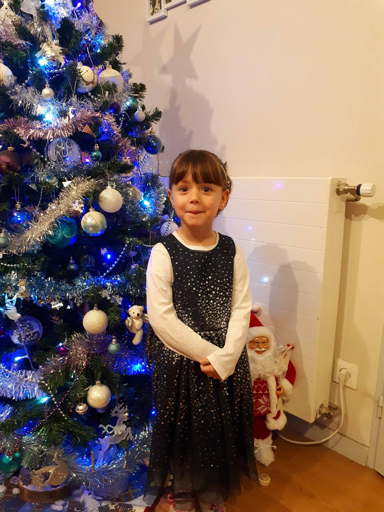 Gwendoline a rejoint le concours — aidez-le/la à gagner de superbes lots ! child, christmas, christmas_decoration, christmas_eve, christmas_ornament, christmas_tree, dress, event, fir, fun, headwear, holiday, holiday_ornament, interior_design, joy, ornament, person, plant, room, standing