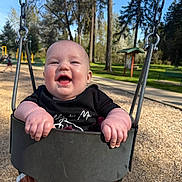 Onyx joined the competition — help win amazing prizes! baby, child, swing, playground, outdoor, smiling, happy, park, trees, sunny, daylight, clothing, seat, metal, chain, woods, nature, fun, cute, person