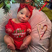 Winslie joined the competition — help win amazing prizes! baby, infant, christmas, holiday, red_clothing, headband, candy_cane, heart_shape, blanket, tree, christmas_lights, festive, cute, smiling, indoors, holiday_decor, holiday_spirit, sitting, person, portrait