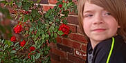 Syrus joined the competition — help win amazing prizes! boy, brick_wall, casual_clothing, child, daylight, flower, garden, green_leaves, ground, natural_light, nature, outdoor, plant, portrait, red_roses, relaxed, short_sleeves, shrubbery, side_view, young