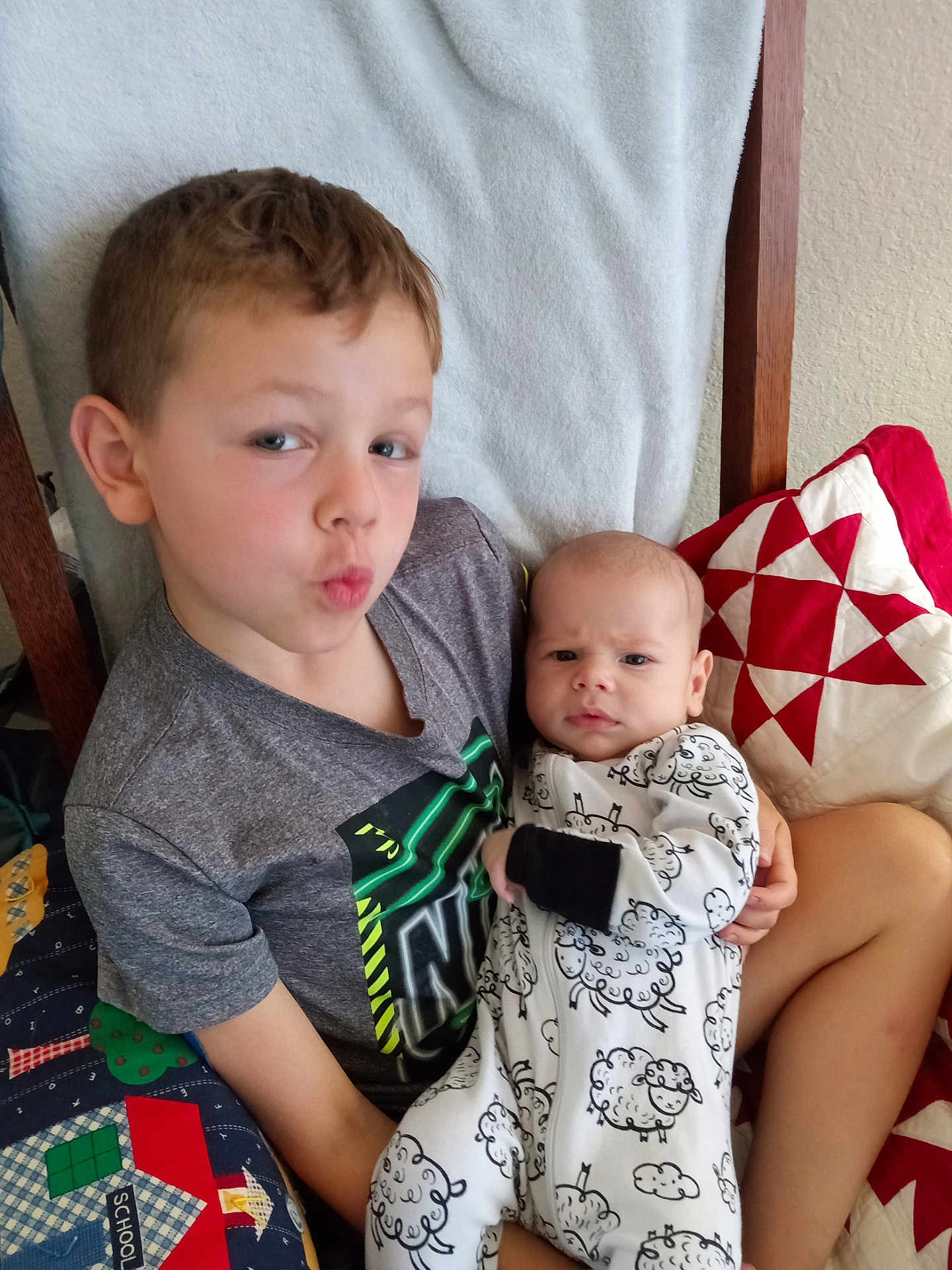 Archer joined the competition — help win amazing prizes! child, baby, boy, infant, clothing, onesie, pillow, quilt, blanket, sitting, indoor, portrait, cute, face, expression, holding, furniture, head, smile, family