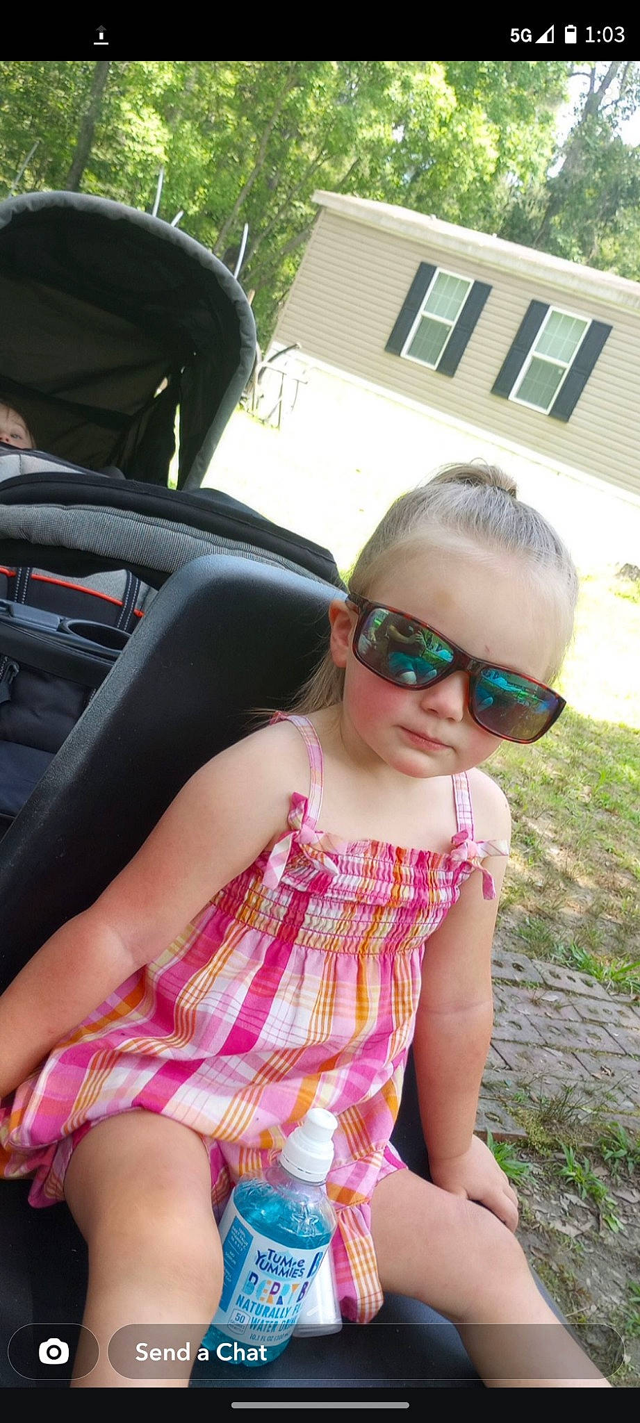 Jazmine joined the competition — help win amazing prizes! automotive_exterior, dress, eyewear, glasses, goggles, grass, hairstyle, leisure, people, person, pink, plant, steering_wheel, summer, sunglasses, thigh, toddler, tree, vehicle_door, vision_care