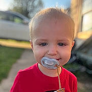 Waylon joined the competition — help win amazing prizes! child, toddler, baby, portrait, outdoor, sunlight, red_shirt, pacifier, blond_hair, blue_eyes, smiling, face, close_up, daylight, backyard, grass, sidewalk, house, vehicle, cord