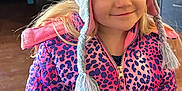 Grace is registered to the contest to win money with this photo: child, girl, hat, knit_hat, cat_ears, jacket, pink, purple, leopard_print, smile, indoor, blonde_hair, face, person, warm_clothing, cute, portrait, young_child, happy, winter_clothes