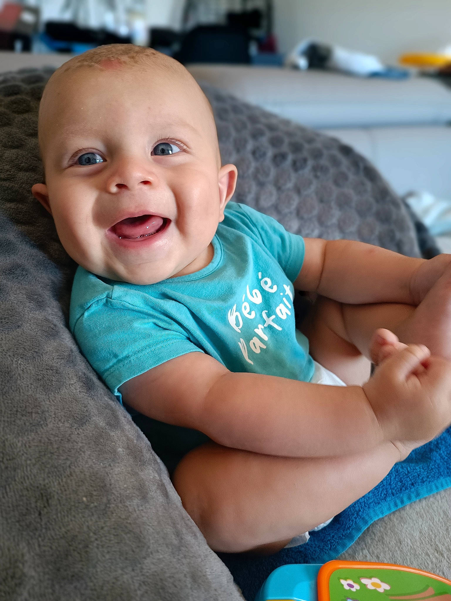 Thyago participe au concours pour gagner de l'argent avec cette photo : baby, baby_toddler_clothing, blue, cheek, child, chin, comfort, couch, electric_blue, finger, fun, hand, happy, mouth, person, sitting, skin, sleeve, smile, t_shirt