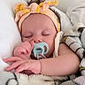 baby, sleeping, pacifier, headband, blanket, infant, closeup, cute, child, soft, cozy, resting, peaceful, indoors, portrait, hand, face, newborn, comfort, toddler