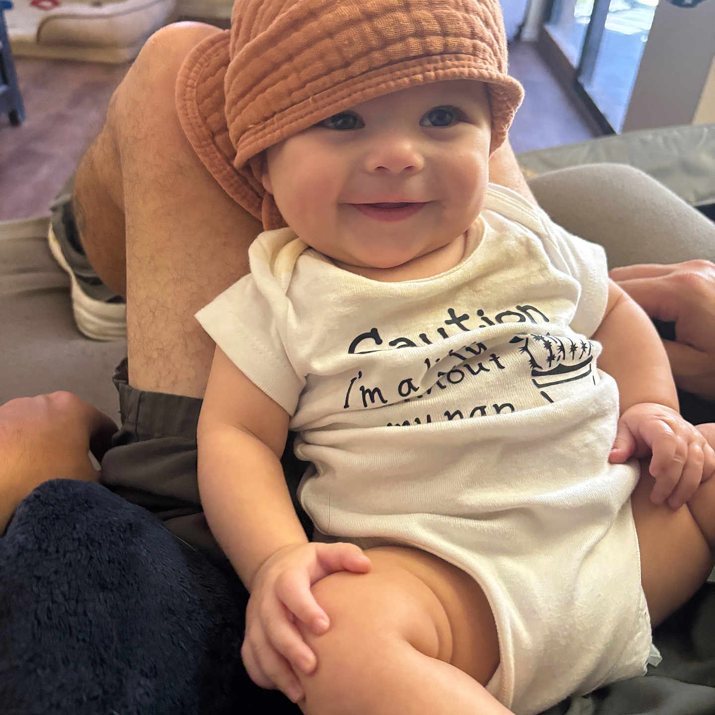 Leighton is registered to the contest to win money with this photo: accessories, baby, bag, beanie, bodypart, bonnet, cap, clothing, couch, face, finger, footwear, furniture, hand, handbag, hat, head, person, shoe, sitting