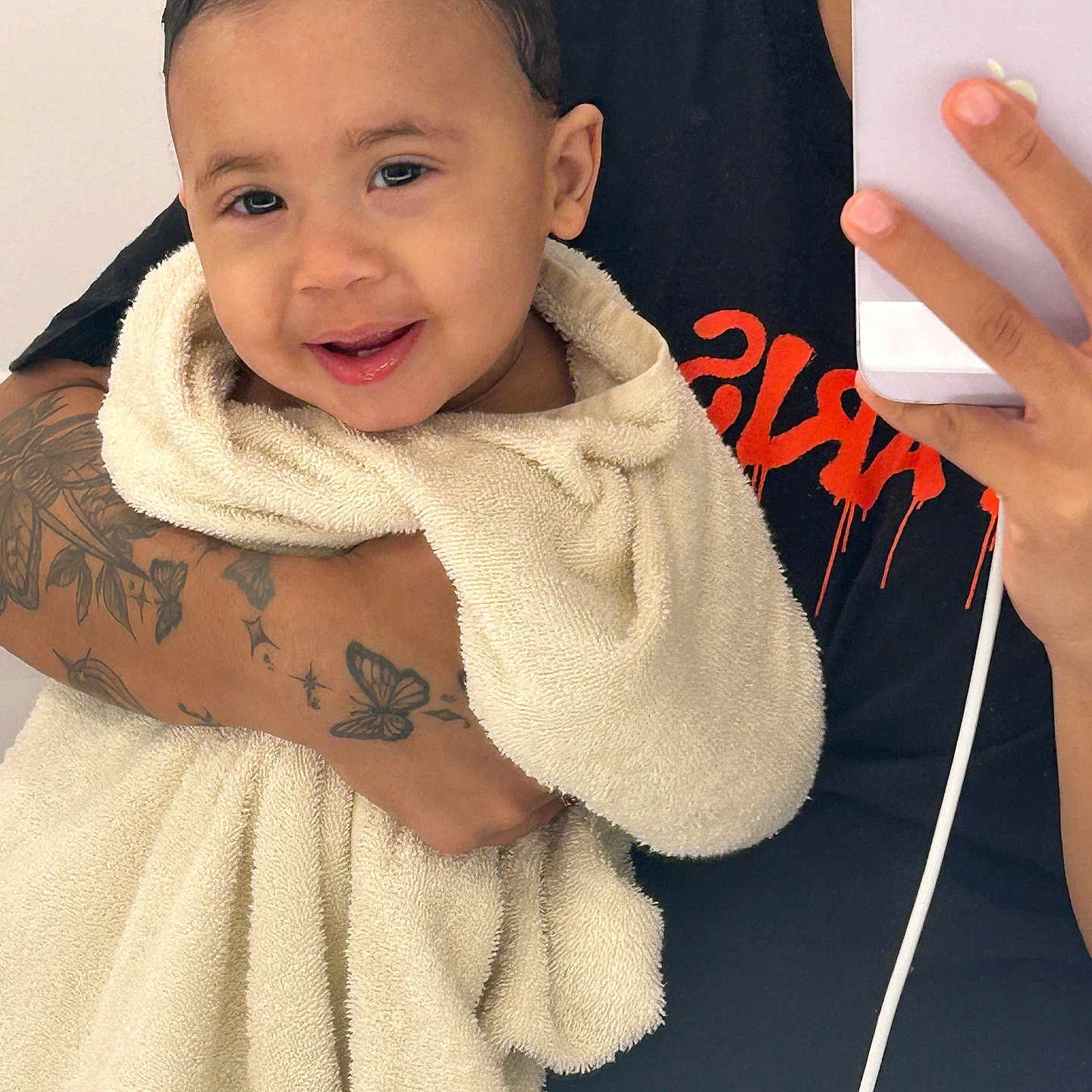 Sebastian Avila Moya is registered to the contest to win money with this photo: arm, black_shirt, child, closeup, cute, face, hand, happy, indoor, mirror, person, phone, portrait, selfie, skin, smiling, tattoo, toddler, towel, wrapped