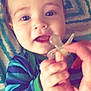 Elijah is registered to the contest to win money with this photo: baby, child, pacifier, hand, face, striped_clothing, blue, green, blanket, indoor, closeup, infant, cute, young_child, person, smiling, expression, reaching, comfort, holding