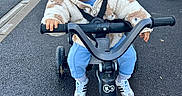 Lino a rejoint le concours — aidez-le/la à gagner de superbes lots ! toddler, child, tricycle, stroller, jacket, hoodie, outdoor, road, pavement, smile, happy, toy, wheels, footwear, sneakers, blue_pants, daylight, urban, parked_car, playtime