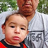 adult, casual_clothing, child, close_up, daylight, expression, face, family, glasses, gray_tshirt, holding, man, nature, outdoor, people, portrait, red_shirt, shirt, toddler, trees