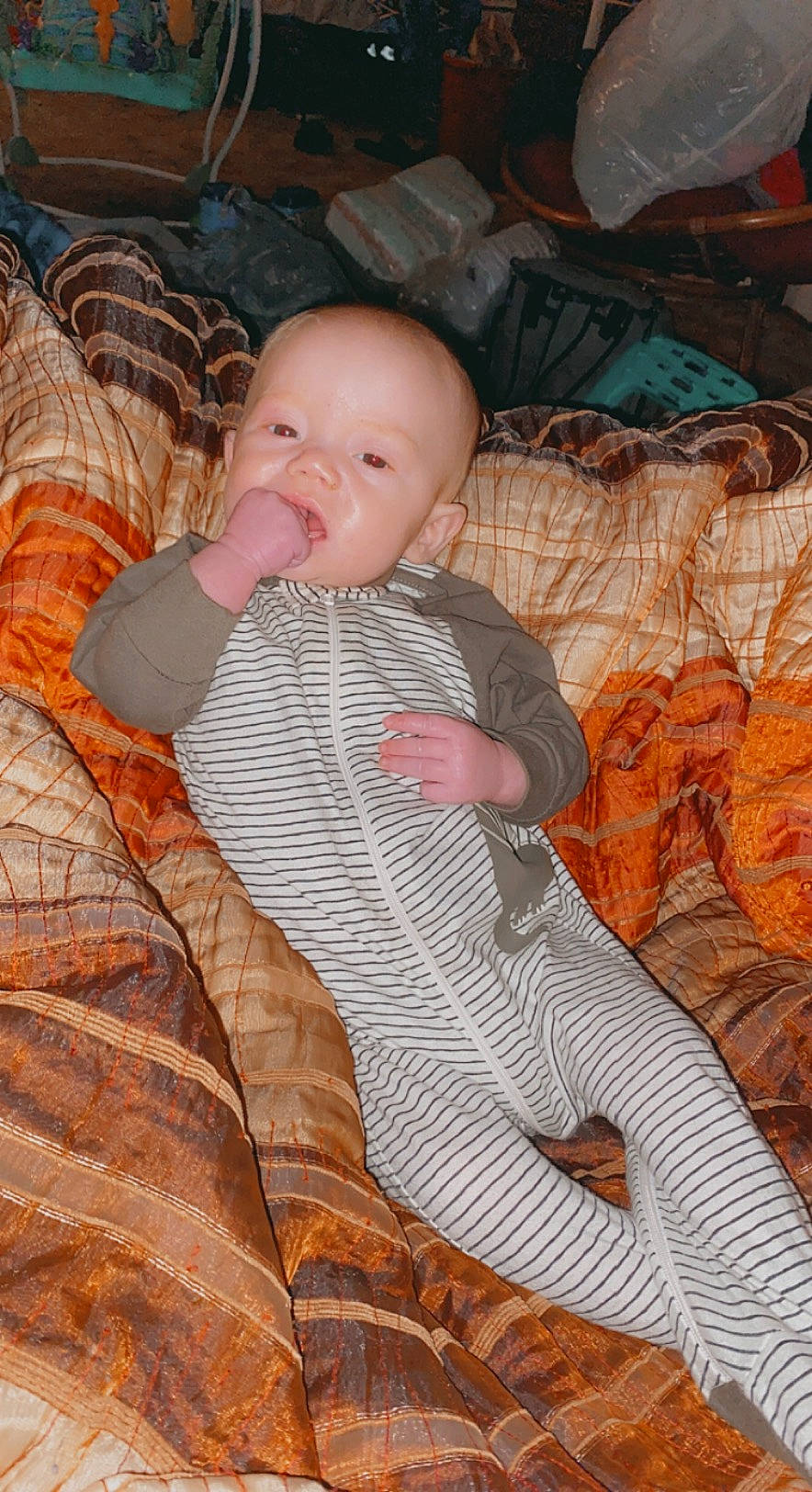 Jaxon is registered to the contest to win money with this photo: arm, baby, baby_products, baby_toddler_clothing, cheek, comfort, dress, eye, finger, foot, hand, head, iris, linens, pattern, person, sitting, skin, textile, toddler