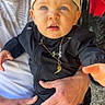 Ezra participe au concours pour gagner de l'argent avec cette photo : toddler, child, baby, cap, blue_eyes, black_jacket, necklace, adult_hand, curious, outdoor, person, portrait, casual_clothing, sitting, grip, close_up, expression, light, indoor, background