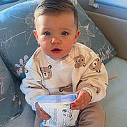 Ezra a rejoint le concours — aidez-le/la à gagner de superbes lots ! baby, child, blue_eyes, sitting, indoors, pillow, bed, clothing, sweatshirt, pants, hand, foot, window, light, face, cute, expression, young, person, cozy