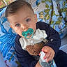 Ezra a rejoint le concours — aidez-le/la à gagner de superbes lots ! baby, pacifier, blue_eyes, sitting, bed, pillow, floral_pattern, clothing, toy, hand, indoor, cute, child, person, face, comfort, bottle, sock, blue, young