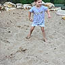 child, girl, sand, playground, barefoot, rocks, greenery, outdoor, grass, shorts, tshirt, playing, movement, smiling, casual_clothing, nature, active, daylight, young, fun