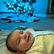 Aneira joined the competition — help win amazing prizes! baby, smiling, infant, blanket, indoor, christmas_tree, holiday, soft_lighting, carpet, face, cute, child, home, cozy, polka_dot, clothing, portrait, cheerful, lying_down, decorations