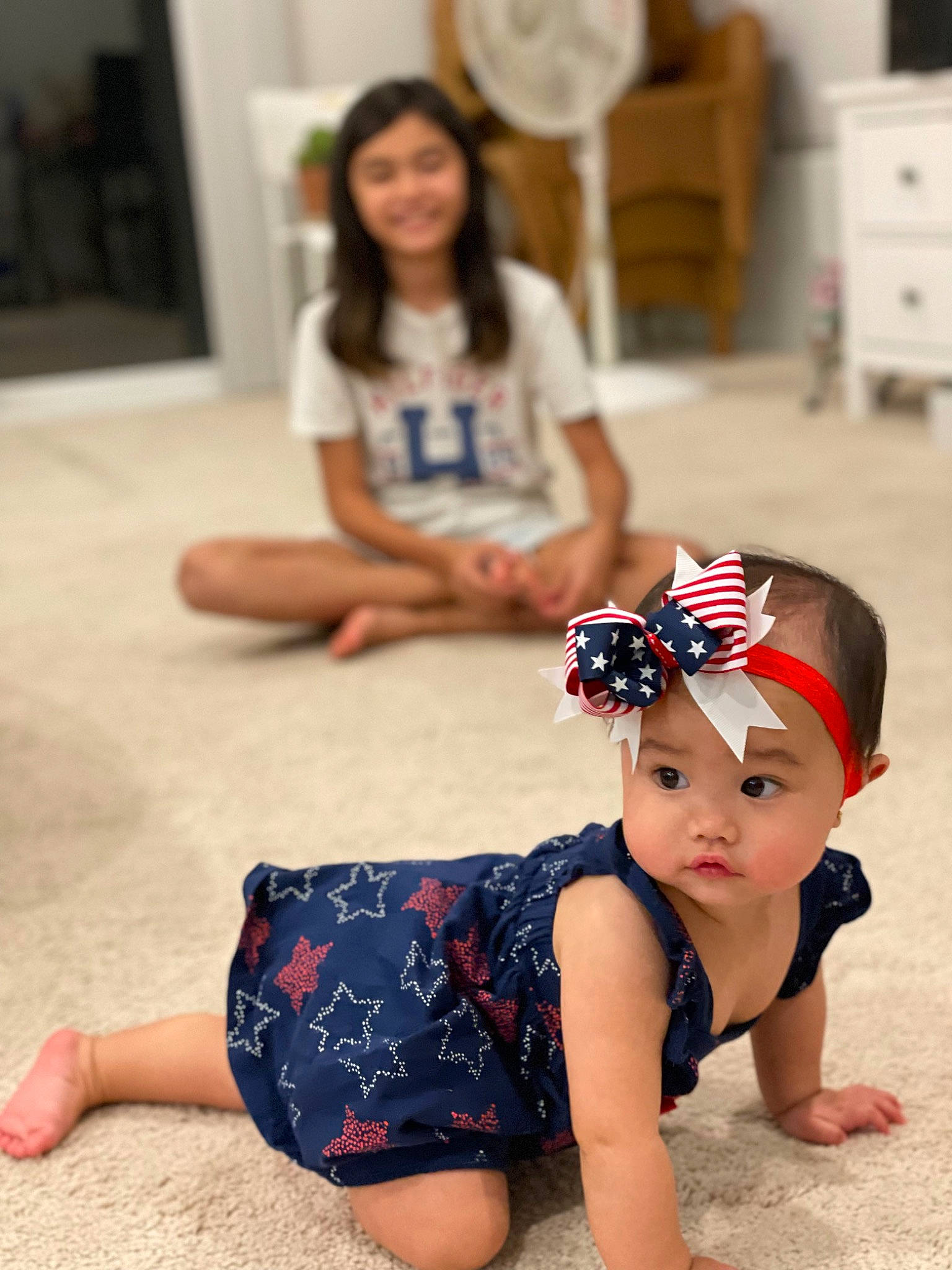 Amelia is registered to the contest to win money with this photo: baby_toddler_clothing, barefoot, blurred, face, facial_expression, finger, floor, flooring, hairstyle, hand, happy, head, headwear, human_body, joy, knee, leg, leisure, person, picture_frame