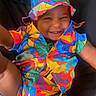 toddler, child, smiling, colorful_clothing, hat, bucket_hat, happy, portrait, baby, casual, cute, indoor, person, fashion, playful, fun, bright_colors, sitting, young_child, joyful