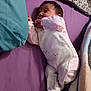 baby, infant, onesie, blanket, pillow, purple, teal, sleeping, cute, clothing, soft, indoor, child, newborn, resting, bed, cozy, person, face, lying_down