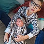 Claudio Teixeira a rejoint le concours — aidez-le/la à gagner de superbes lots ! child, baby, glasses, holding, indoor, pillow, patterned_clothing, headband, striped_dress, sitting, couch, family, young_child, infant, comfort, portrait, casual, happy, cozy, home