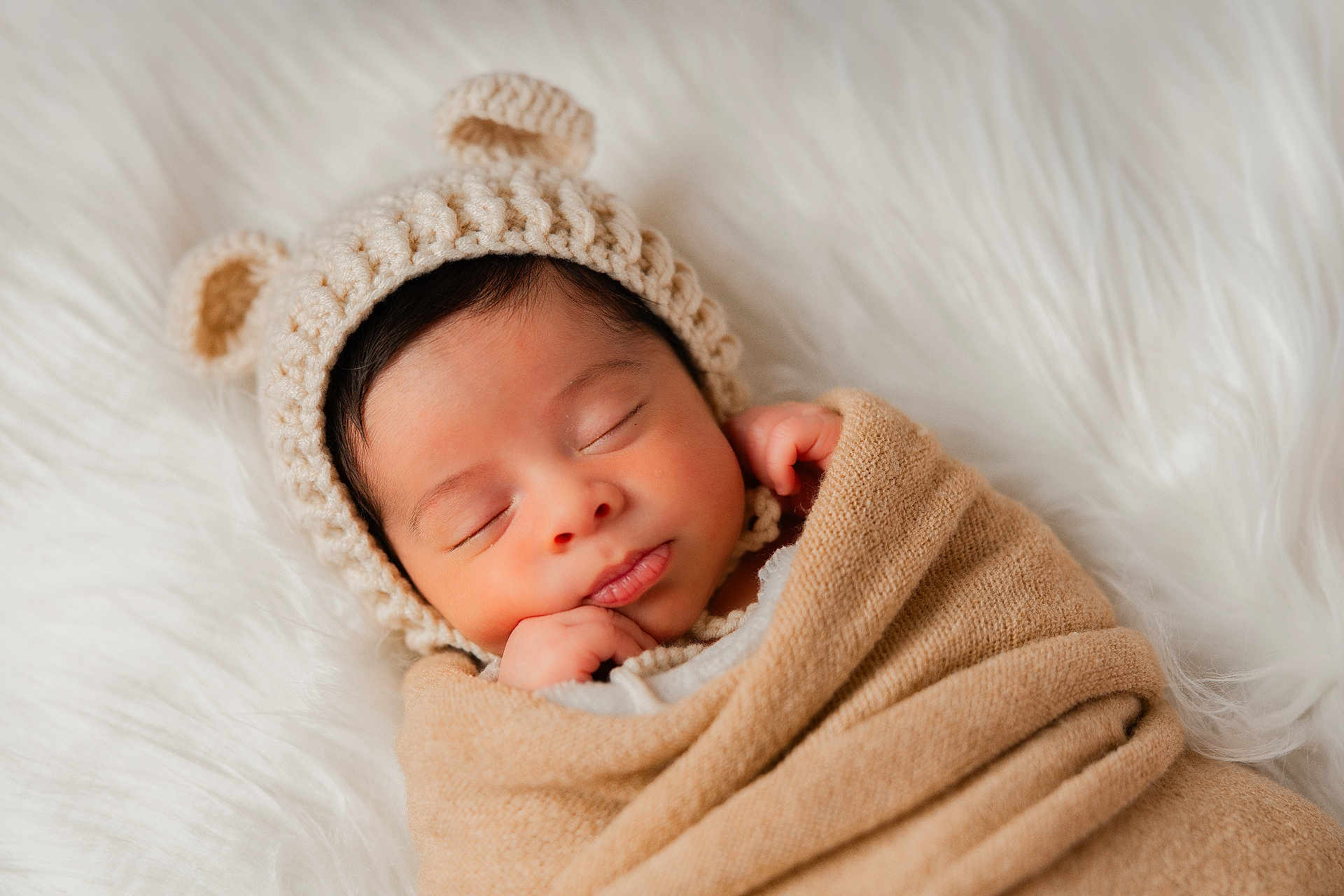 Adam joined the competition — help win amazing prizes! baby, newborn, sleeping, knit_hat, bear_ears, blanket, swaddle, cozy, faux_fur, portrait, infant, peaceful, closed_eyes, hand_near_face, soft_texture, beige, white_background, studio_photography, cute, headshot