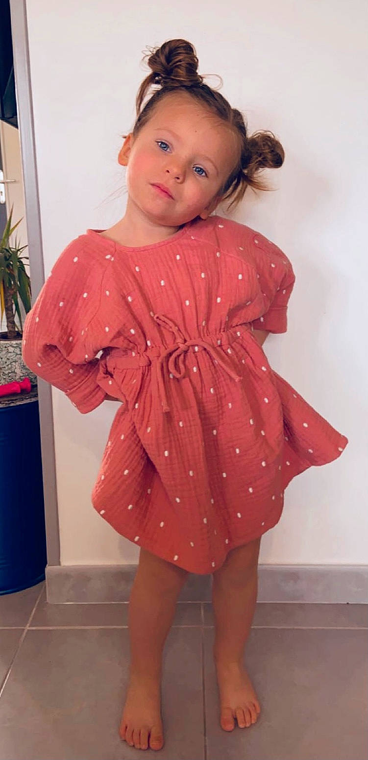 Mia participe au concours pour gagner de l'argent avec cette photo : baby_toddler_clothing, day_dress, dress, hair, hairstyle, head, houseplant, iris, joint, lip, neck, one_piece_garment, person, pink, red, shoulder, skin, sleeve, toddler, waist