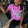 child, girl, smiling, braids, beads, pink_shirt, barbie, indoor, chair, fan, black_leggings, happy, portrait, person, casual, seated, hair_accessories, young, cute, playful