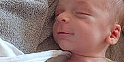 Eden a rejoint le concours — aidez-le/la à gagner de superbes lots ! baby, sleeping, blanket, soft, patterned_sheet, animal_print, leaf_print, infant, peaceful, smile, skin, head, ear, torso, white_clothing, bed, rest, closeup, newborn, cozy
