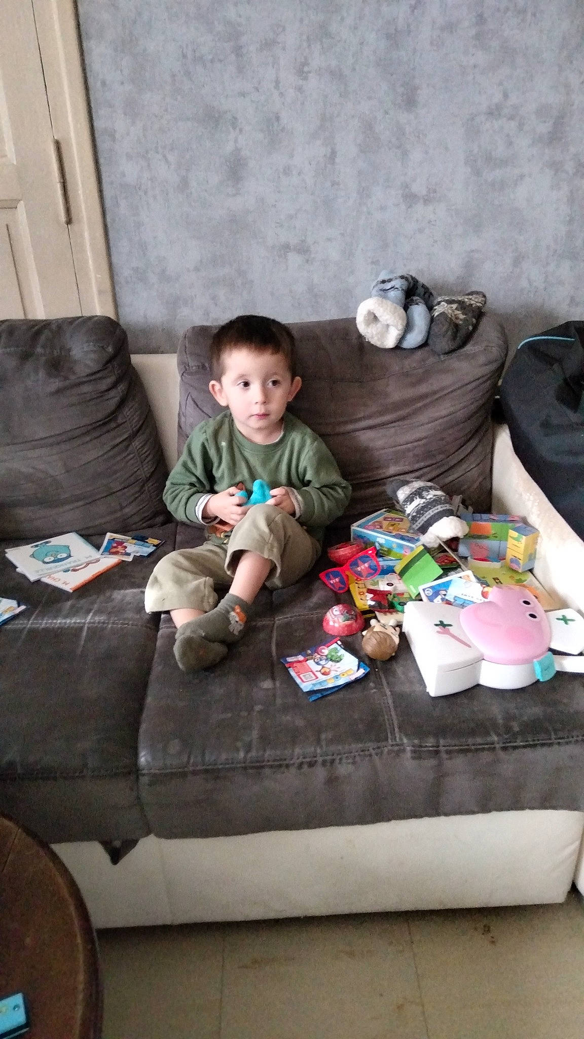 Tiago participe au concours pour gagner de l'argent avec cette photo : baby, baby_toddler_clothing, child, comfort, couch, flooring, fun, hardwood, holiday, lap, living_room, luggage_and_bags, people, person, play, room, sitting, sock, textile, toddler