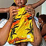 Mulani is registered to the contest to win money with this photo: baby, child, toddler, face, hands, feet, dress, yellow, orange, patterned_clothing, adult_hands, indoor, window, people, seated, room, casual, portrait, holding, family