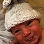 baby, infant, hat, knitted_hat, bunny_ears, cute, tongue_out, face, skin, eyes, blanket, bed, indoors, child, newborn, portrait, expression, headwear, soft_lighting, closeup