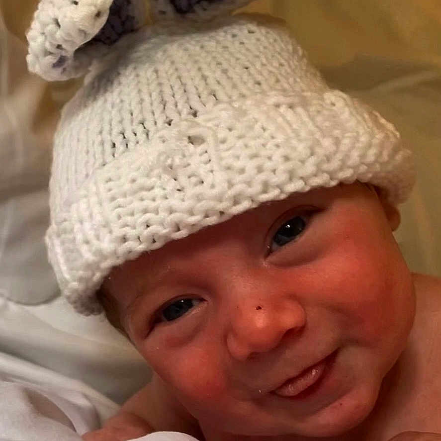 Aaron a rejoint le concours — aidez-le/la à gagner de superbes lots ! baby, bed, blanket, bunny_ears, child, closeup, cute, expression, eyes, face, hat, headwear, indoors, infant, knitted_hat, newborn, portrait, skin, soft_lighting, tongue_out