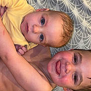 Lyzio a rejoint le concours — aidez-le/la à gagner de superbes lots ! baby, child, siblings, curly_hair, blue_eyes, brown_eyes, patterned_blanket, indoor, playful, tongue_out, close_up, face, skin, cuddle, happy, bare_chest, family, toddler, infant, home