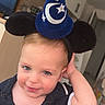 toddler, child, boy, hat, wizard_hat, mickey_mouse_ears, smile, blue_eyes, indoor, kitchen, cabinet, shirt, black_shirt, short_sleeves, light_skin, cute, playful, portrait, young_child, headwear