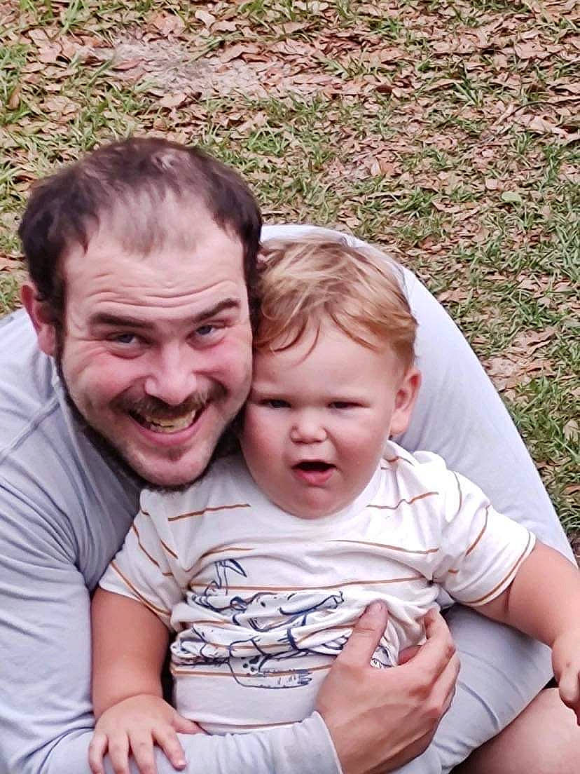 Joseph is registered to the contest to win money with this photo: baby, cheek, eye, facial_expression, fun, gesture, grass, hairstyle, happy, human_body, interaction, joy, mammal, people, people_in_nature, person, photograph, plant, skin, smile