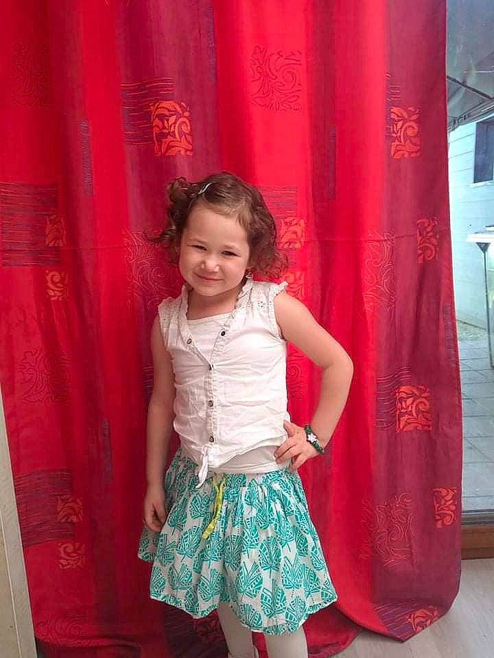 Elèanore a rejoint le concours — aidez-le/la à gagner de superbes lots ! baby_toddler_clothing, child, curtain, day_dress, fashion, fashion_design, fun, happy, joy, magenta, person, pink, red, shoulder, sleeve, smile, standing, textile, thigh, toddler