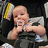 baby, infant, child, car_seat, pacifier, sitting, portrait, face, eyes, smiling, clothing, harness, seat_belt, shopping_store, grocery_shelves, indoor, safe, vehicle_seat, photography, adorable