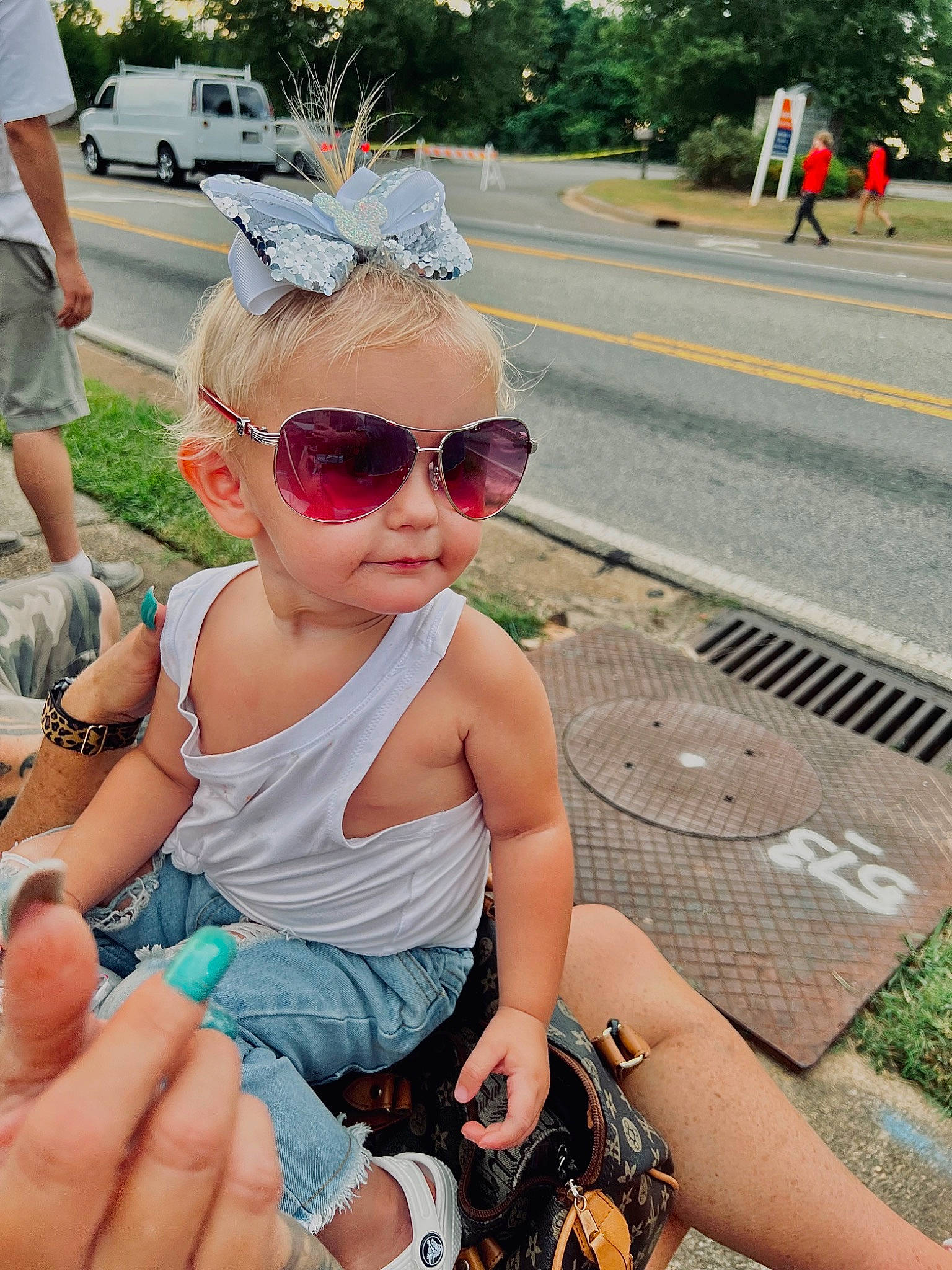 Kimber is registered to the contest to win money with this photo: asphalt, baby_toddler_clothing, eyewear, flag, fun, glasses, goggles, grass, happy, leisure, person, personal_protective_equipment, plant, recreation, road_surface, shoe, shorts, sunglasses, toddler, tree