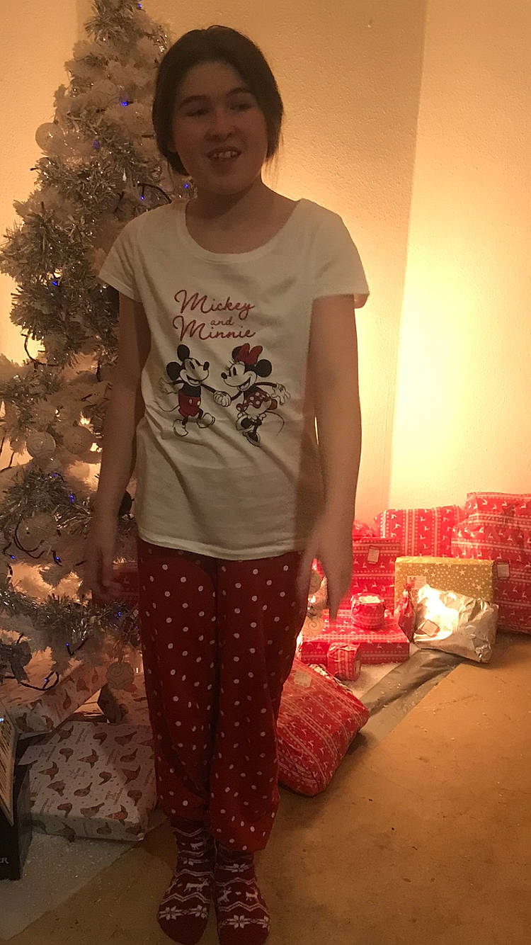 Archie Reynolds joined the competition — help win amazing prizes! christmas_tree, conifer, event, fashion_design, flooring, fun, happy, holiday, joy, magenta, pattern, person, room, sitting, sleeve, smile, standing, t_shirt, tradition, tree