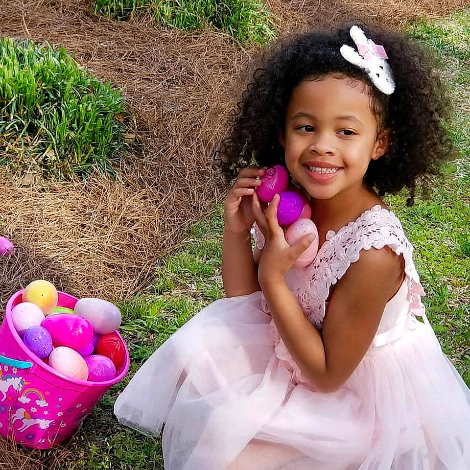 Amelia is registered to the contest to win money with this photo: black_hair, child, easter, flower, fun, girl, grass, hair_accessory, happiness, headgear, infant, joy, person, petal, pink, play, smile, spring, toddler