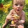 barefoot, child, cone, curly_hair, cute, daytime, food, grass, happy, ice_cream, messy, nature, outdoor, play, sitting, skin, summer, sunlight, toddler, toy