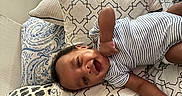 Dwane Jr. joined the competition — help win amazing prizes! baby, infant, smiling, striped_clothing, bed, pillow, patterned_textile, adult_arm, indoor, happy, person, sleepwear, cushion, lying_down, skin, hand, face, child, resting, home