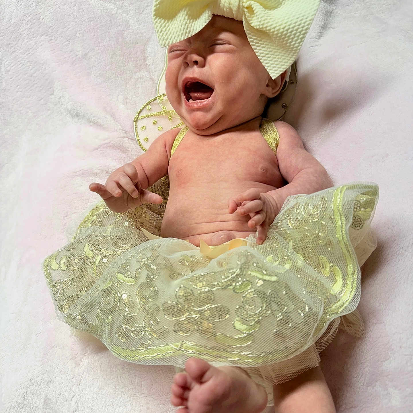 Khaliah joined the competition — help win amazing prizes! baby, crying, infant, tutu, bow, yellow, clothing, barefoot, expression, skin, blanket, laying, child, cute, adorable, small, young, person, indoor, soft