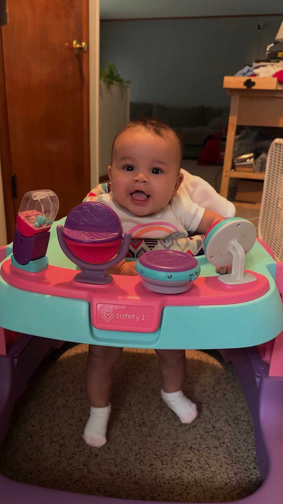 Kollyns is registered to the contest to win money with this photo: baby, walker, toy, indoor, child, smiling, happy, feet, socks, carpet, door, furniture, person, face, head, clothing, playtime, floor, infant, room
