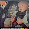 baby, infant, sleeping, car_seat, harness, seatbelt, vehicle, portrait, close_up, face, hands, legs, cream_clothing, gray_car_seat, red_buckle, warning_label, snapchat, text_overlay, heart_emojis, indoor