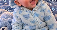Malachi is registered to the contest to win money with this photo: baby, child, infant, smiling, portrait, blue, onesie, hood, bear, teddy_bear, blanket, plush, sitting, indoors, cozy, happy, cute, face, text_overlay, hearts